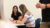 Two Dordt Students sitting down at a table looking at each other and smiling