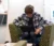 A Dordt student sitting down in a chair working on his laptop with headphones on