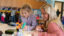 A Dordt student sitting down with an elementary student