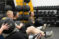 A group of health students sitting down with medicine balls doing Russian twists