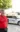 A Midwest Honor Flight organizer stands in front of a vehicle and trailer bearing the Midwest Honor Flight logo