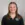 Photo of smiling young lady with straight hair wearing black quarter-zip