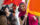 Female in pink hood holding flag while other international flag is displayed in background