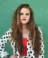 A picture of a women wearing a black and white polka-dot jacket with long brown hair