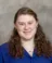 A picture of a women with brown hair wearing a blue shirt