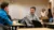 Male student turns around in his seat to talk to a classmate