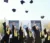 A picture of graduates in robes throwing their graduation caps in the air