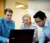 A picture of Dr. Sandouka helping two students with a programming problem
