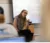 Professor sits at the front of class and points to a student as she chats