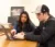 A female student tutors a male student using a laptop