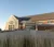 Campus Center building and clocktower in early morning with tallgrasses in the foreground