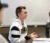 Male student participates in his class, gesturing with his hands as he talks