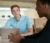 a male student sits at a laptop and listens to another student