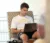 a male student sits in the lounge and types on his computer