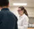 A student in a lab coat interacts with a professor in a lab