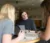 Three female students sit around a table with their laptops and textbooks