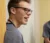 A student in scrubs smiles at someone off-camera
