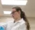A female student holds something in a white coat and blue disposable gloves