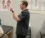 A faculty member describes a concept using his hands, as he stands next to a table with a diagram of muscle anatomy on the wall behind