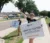 Two students wave and hold up week of welcome signs