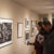 People look at drawings in an art gallary