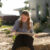 Female student sits outside and sketches on a sunny day