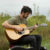 A student plays guitar in the prairie