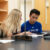 two physics students discuss handout in front of them
