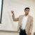Dr. Justin Bailey points to information on the classroom whiteboard