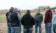 A picture of a professor talking to students in a field