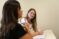 Two female students interact in a classroom