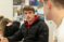 Male student sits with pen poised as he talks with another student in class