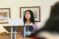 Female student standing at podium with computer