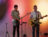 Two male students play guitar and bass on stage