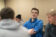 Male student standing with arms crossed in classroom taking it all in