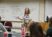A social work professor lectures in the front of class with a whiteboard full of notes behind her