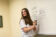 female student draws up tables on classroom whiteboard