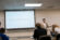 Dr. Justin Bailey presents a PowerPoint and lectures in front of the class