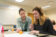 two female students discuss math project with oranges