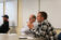 Two male professors discuss with each other at faculty meeting