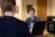 Male student presents on his laptop in the grille area to another student