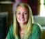 A picture of a women with blond hair wearing a green shirt