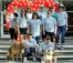 A group of people in matching shirts pose for a picture in front of a red balloon heart