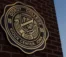 A picture of the old Dordt College seal on a brick structure.