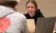 Female student looks up and discusses something with male student across from her in class