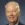 Older man in suit and tie smiles