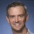 Smiling man with brown eyes and sparse goatee